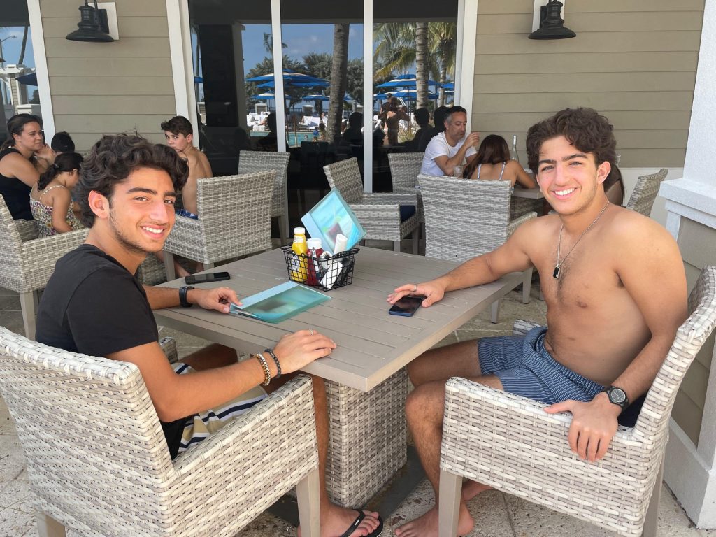Two boys sitting outside smiling