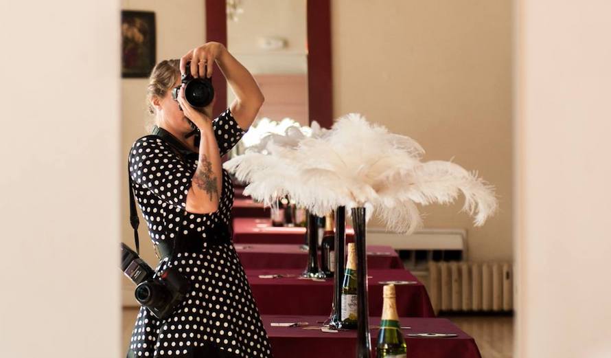 woman taking photo of herself in mirror with flowers and champagne bottles
