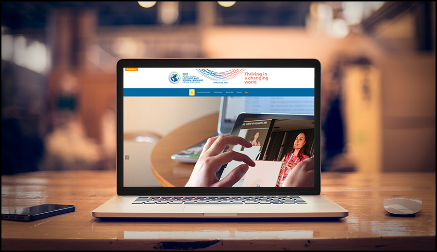 A laptop on a desk displaying a website about thriving in a changing world, with assistance from a wireless mouse next to it.