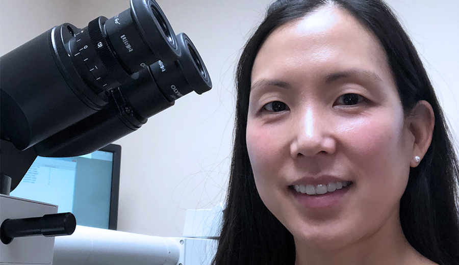 female doctor sitting by microscope